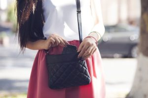 黒いバックを持つ女性の顔から下